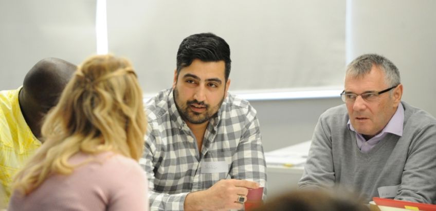Three males and a female sitting down talking to each other